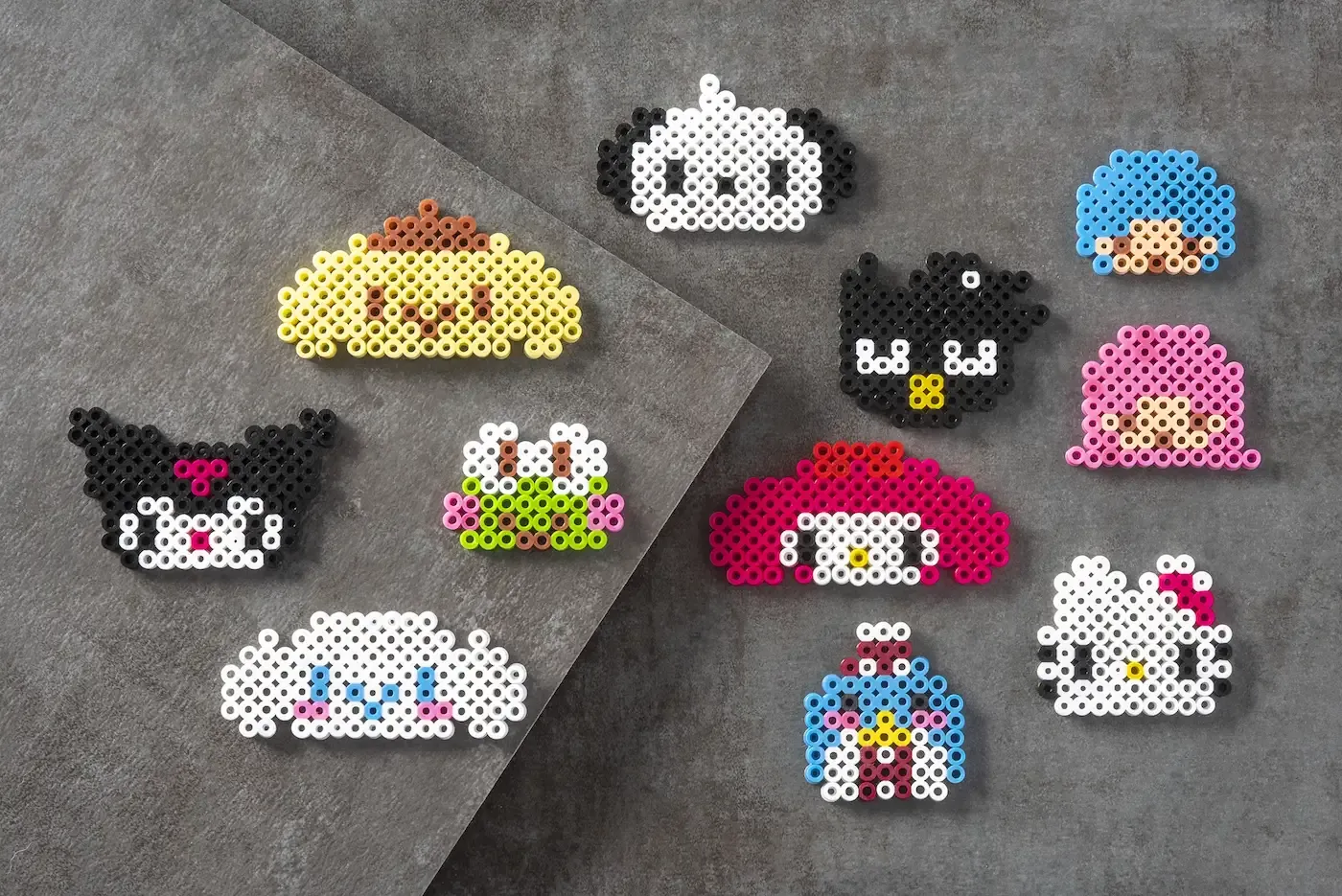 Colorful perler bead creations featuring popular Sanrio characters like Hello Kitty and Kuromi.